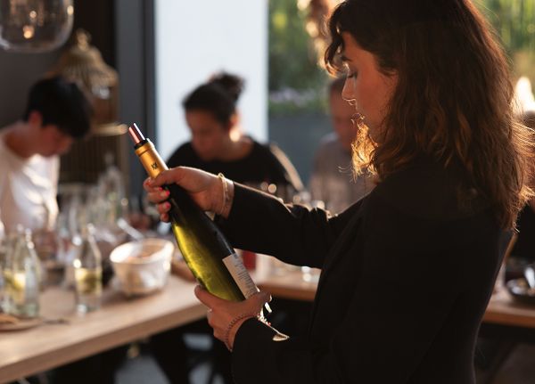 Laura Schaut auf eine Flasche Weißwein